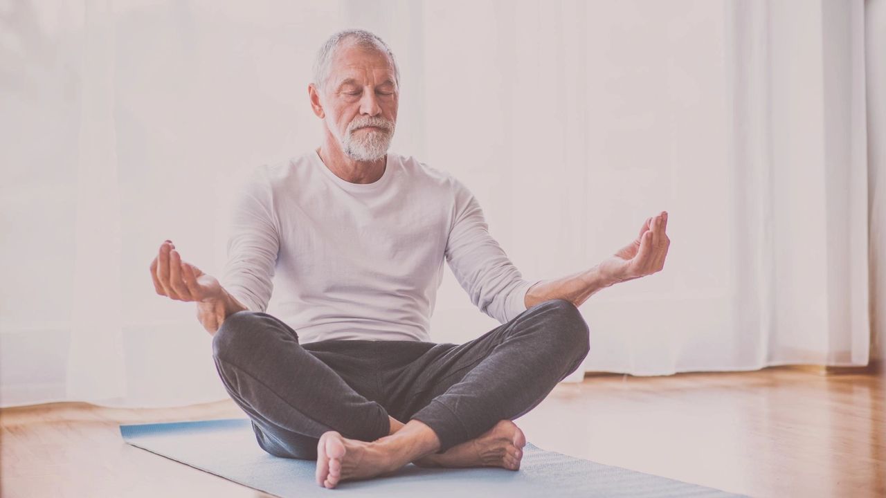 A man meditates on a yoga mat as part of his new plan to practice self care.