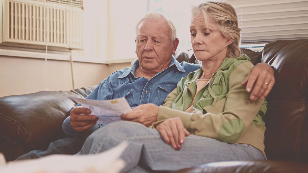 A middle aged couple are distressed about the cost of living crisis after receiving a utility bill.