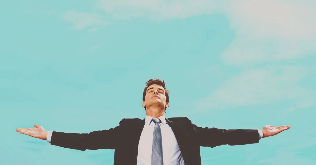 A man raises his hands to the sky in relief after learning how to embrace change.